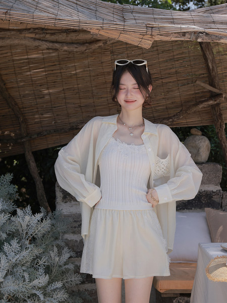 Cream layered summer outfit worn by a model outdoors