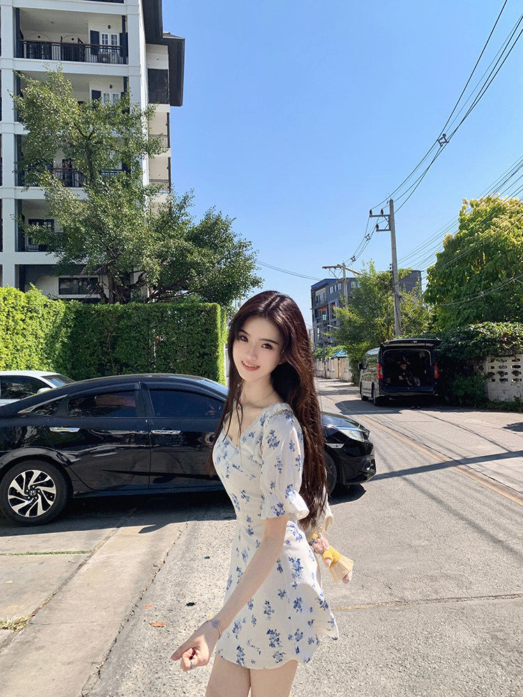 Woman wearing a floral dress outdoors on a sunny day