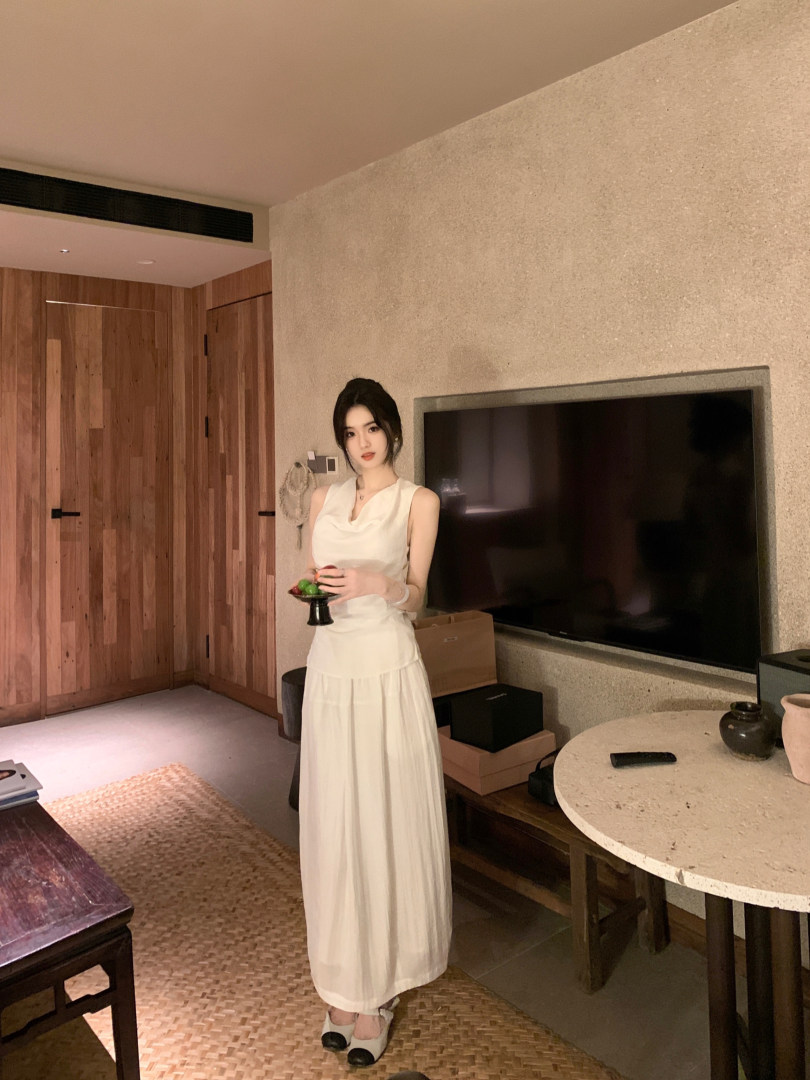Woman wearing a white sleeveless dress in a modern room