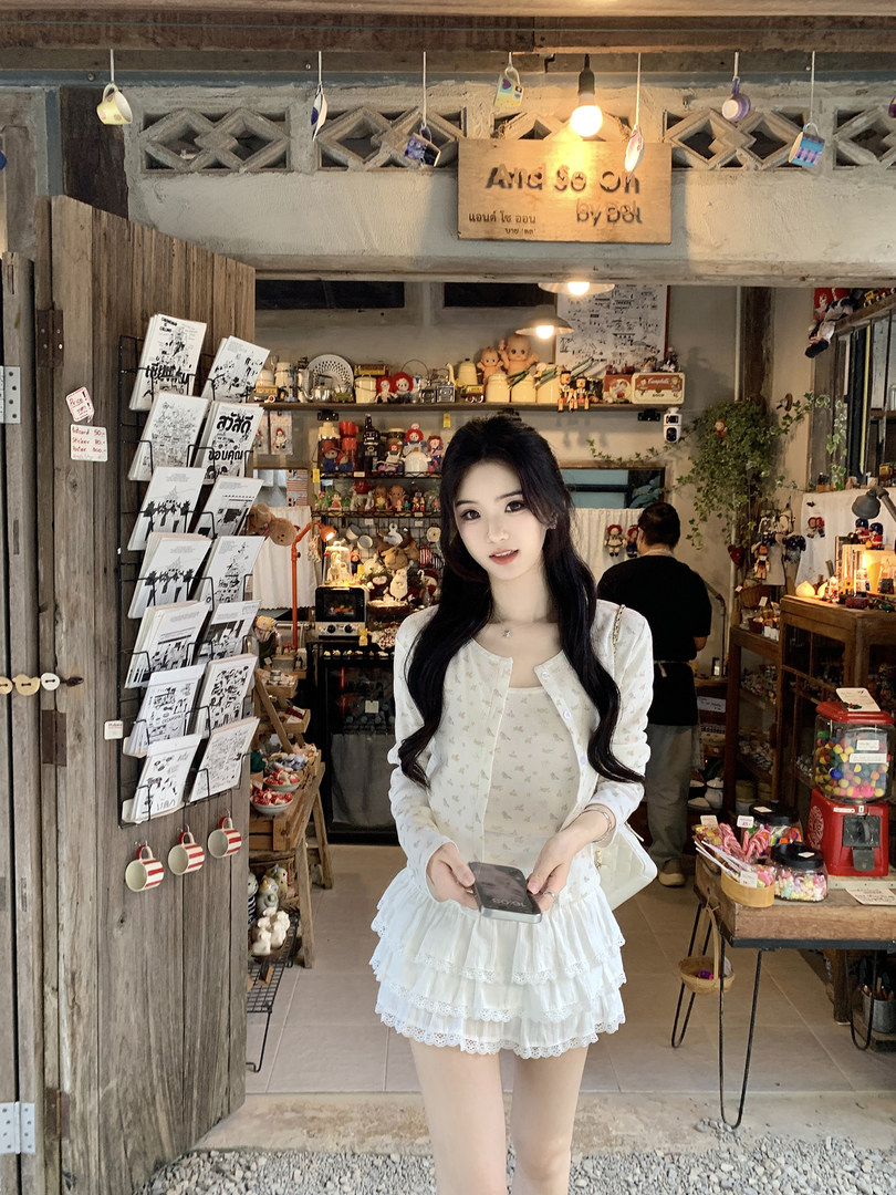 Woman wearing a white floral dress with lace details in a shop setting