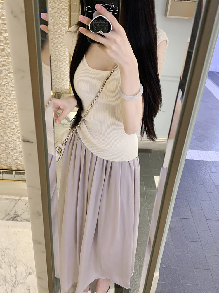 Woman taking mirror selfie wearing cream ribbed top and lavender pleated skirt