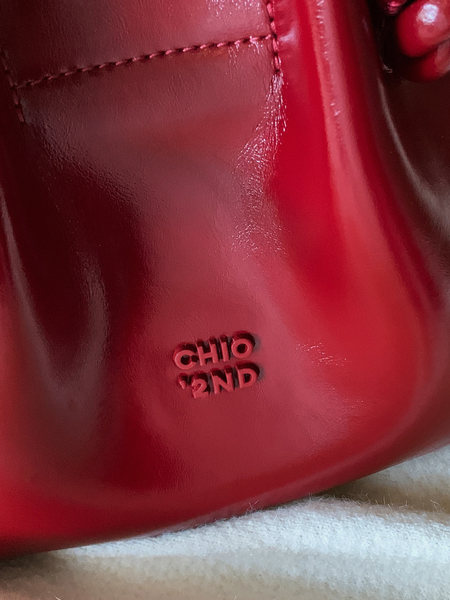 Close-up of a glossy red leather accessory with embossed branding