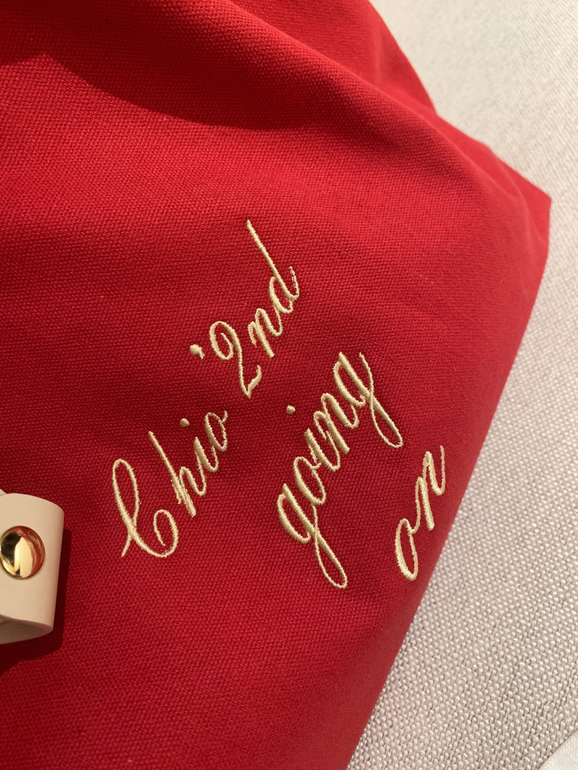 Close-up of a red embroidered fabric clutch or bag with gold hardware