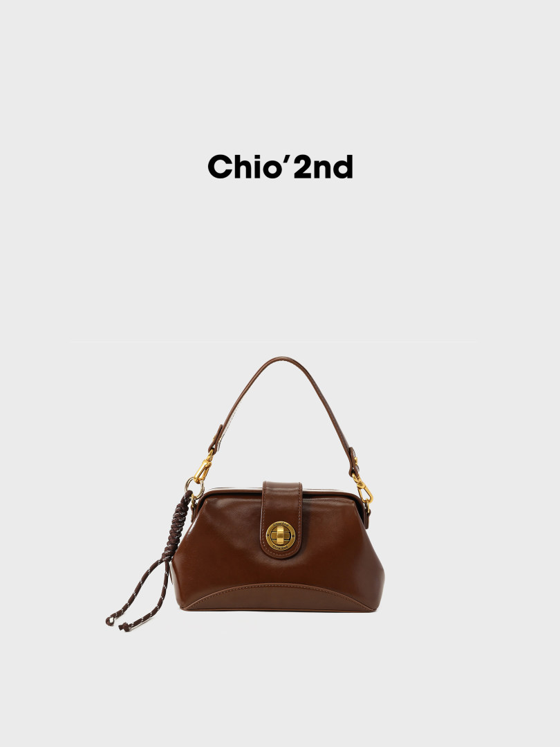 Brown leather handbag with gold hardware on a white background