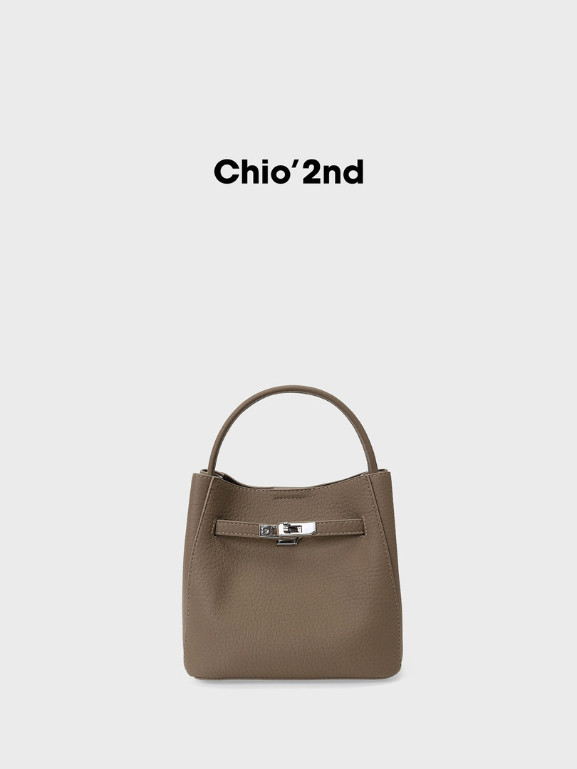 Taupe leather handbag with top handle and front clasp on a white background