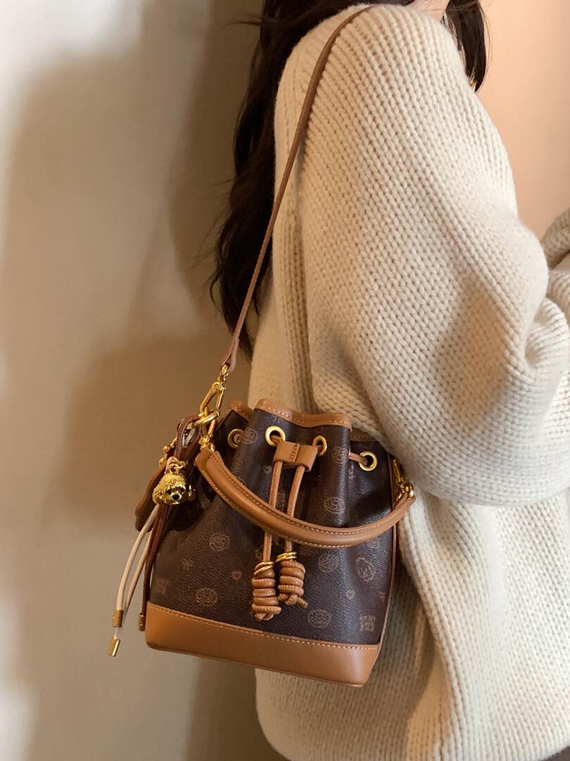 Brown monogram bucket handbag worn on a model