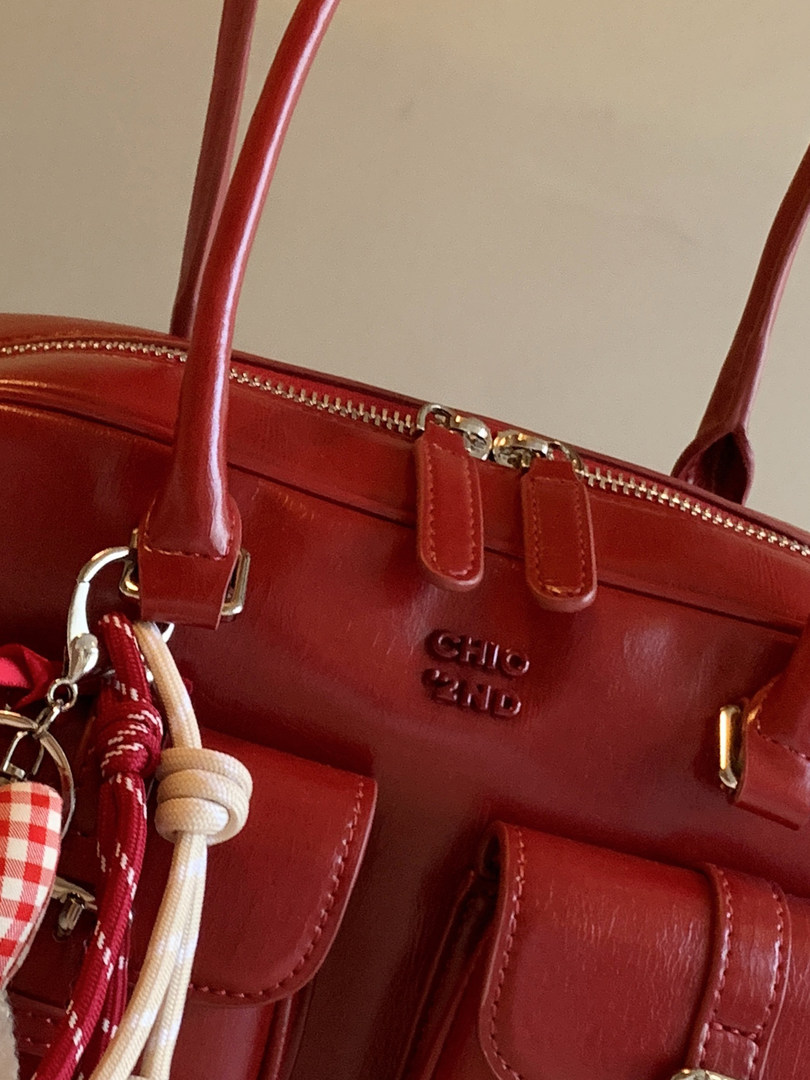 Red leather handbag with gold hardware and hanging charms