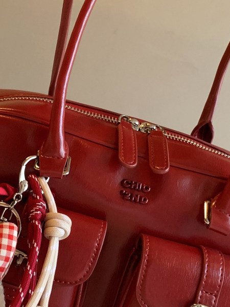 Red leather handbag with gold hardware and hanging charms