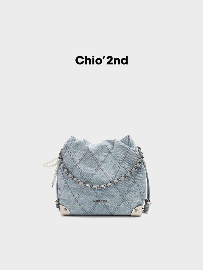 Light blue quilted denim chain shoulder bag on white background