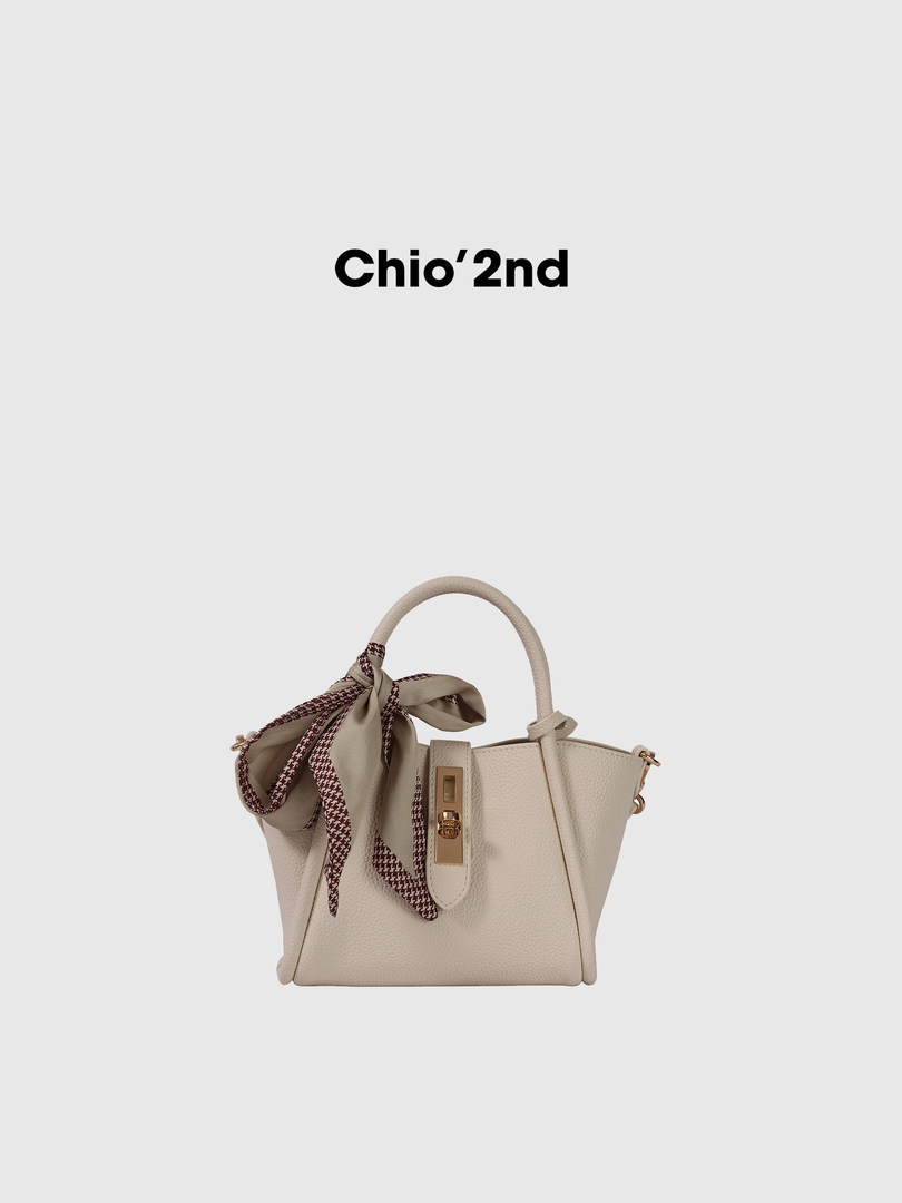 Beige structured handbag with a decorative scarf bow and top handle
