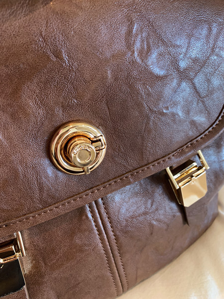 Brown leather handbag with gold hardware close-up