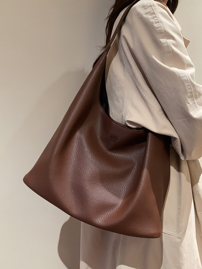 Brown leather tote bag worn on a model