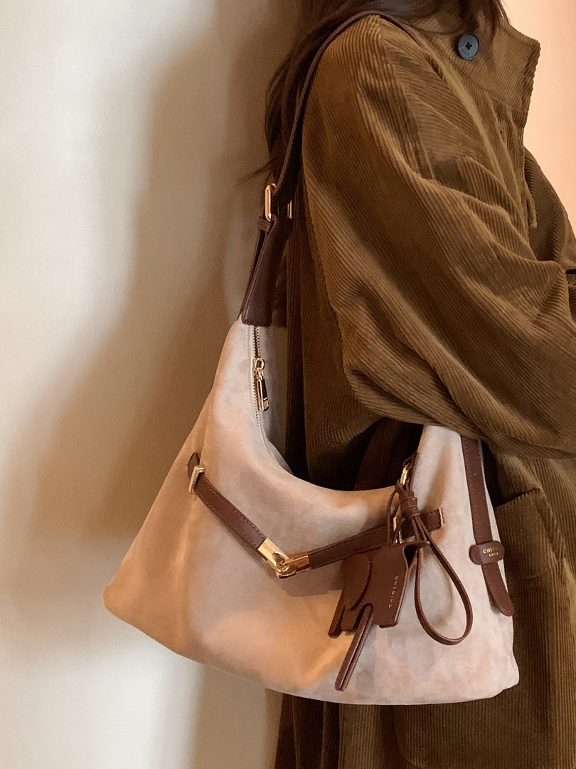 Woman wearing a beige and brown shoulder bag