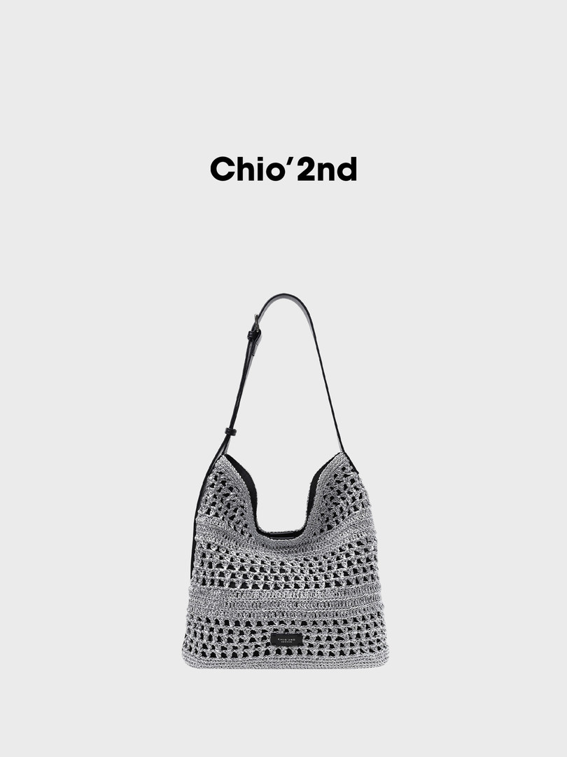 Crochet woven shoulder bag with black trim and long strap on white background