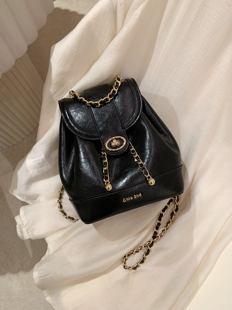 Black leather backpack with gold chain details