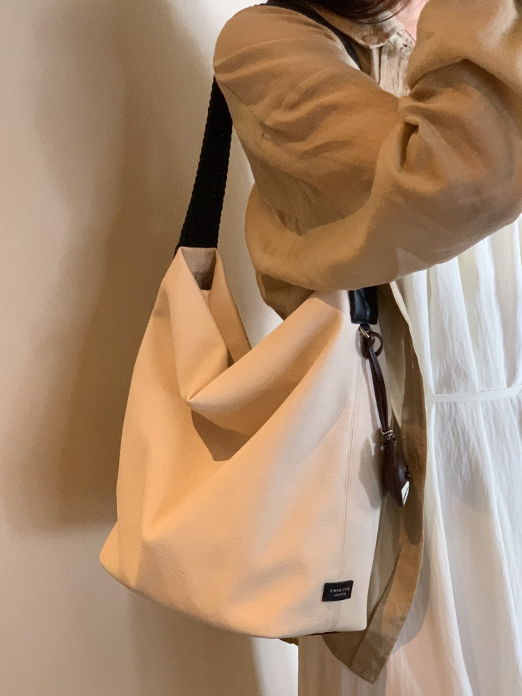 Beige shoulder tote bag worn by a model
