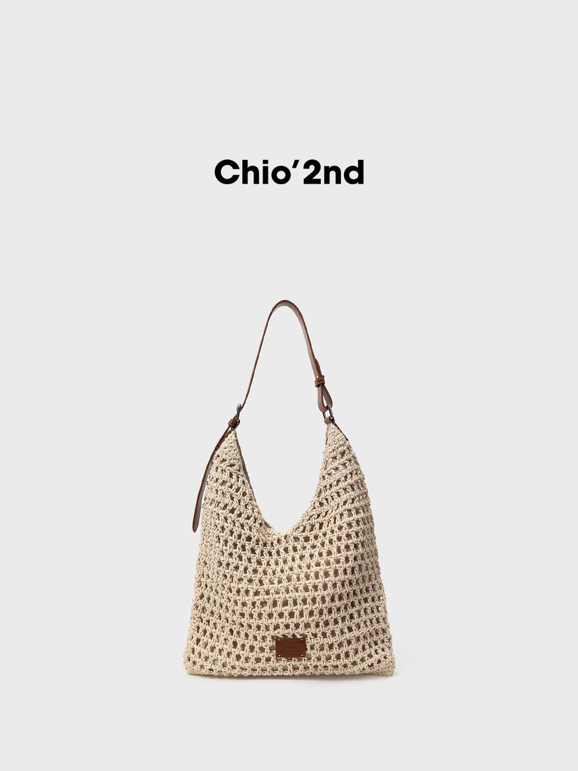 Beige woven shoulder bag with brown strap on a plain background
