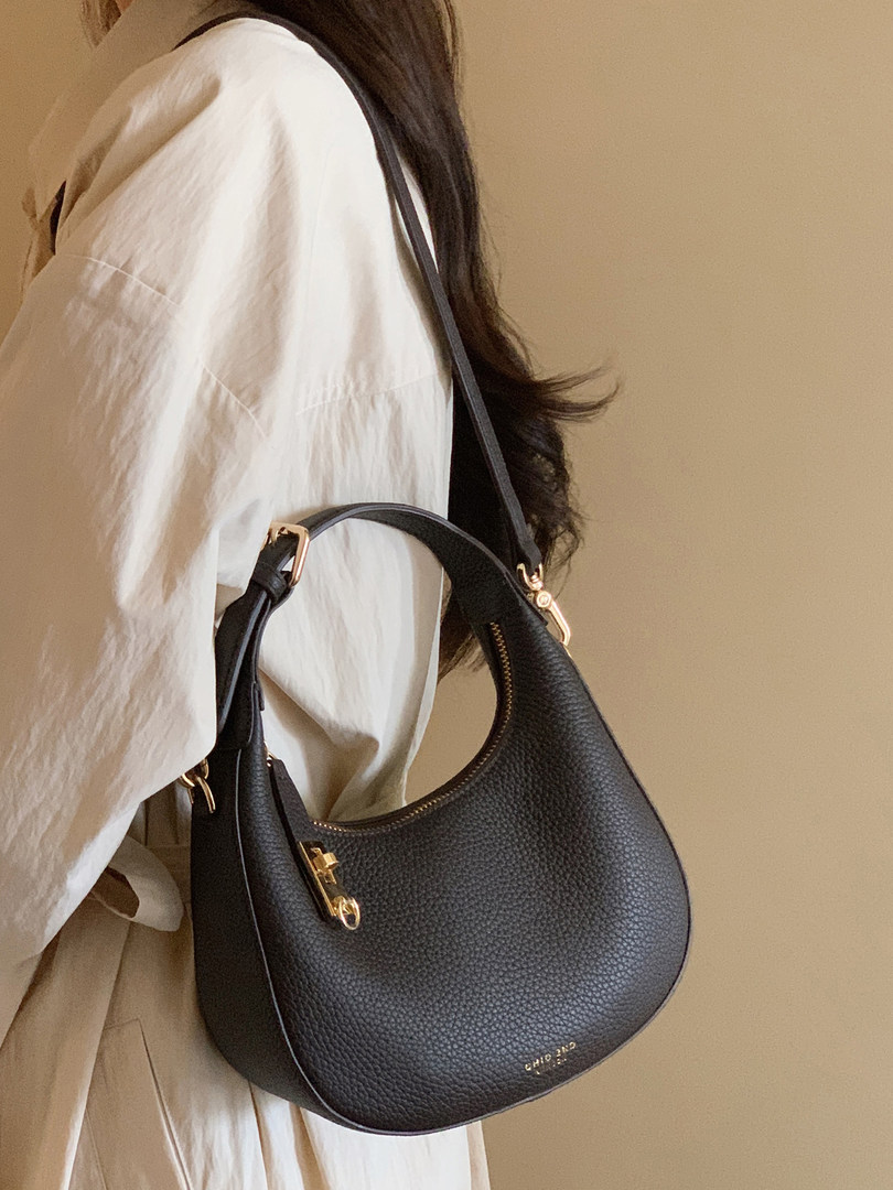 Black textured shoulder bag worn by a model