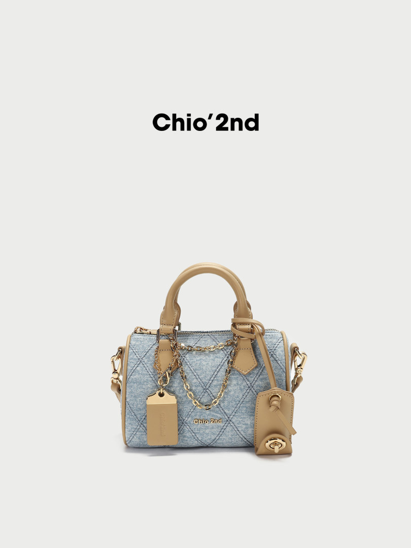 Light blue and beige small handbag with chain and top handle on white background