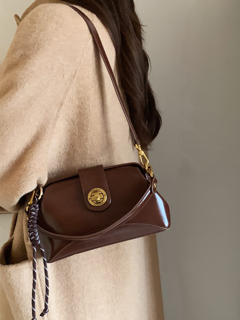Brown leather shoulder bag worn crossbody on a model