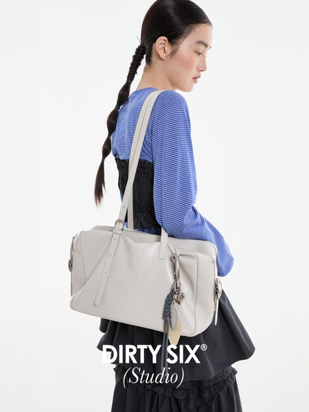 Light gray shoulder bag worn by a model with a brand logo overlay