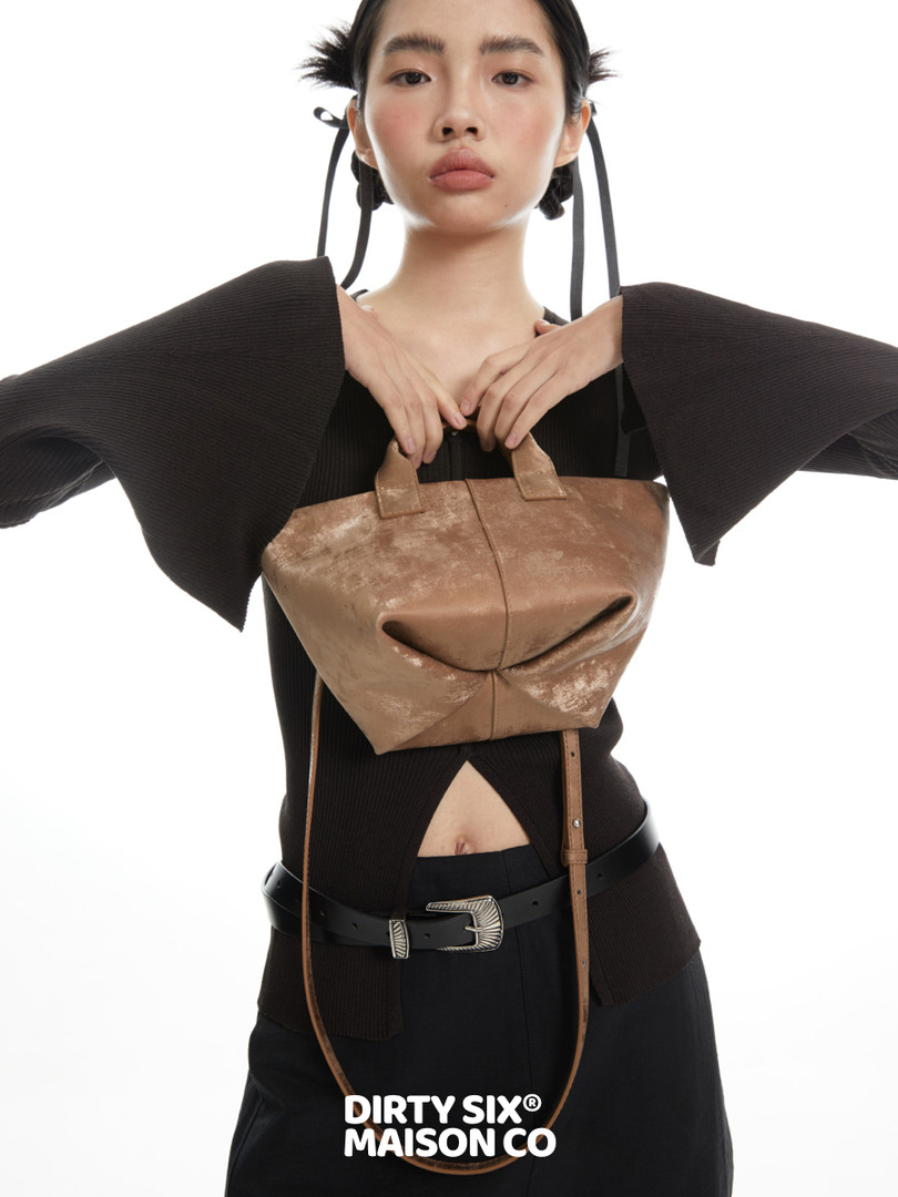 Brown leather handbag worn by a model with a fashion editorial look