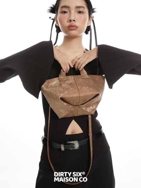 Brown leather handbag worn by a model with a fashion editorial look