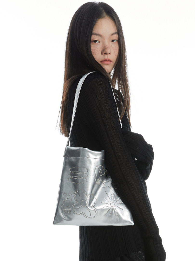 Silver metallic shoulder tote bag worn by a model