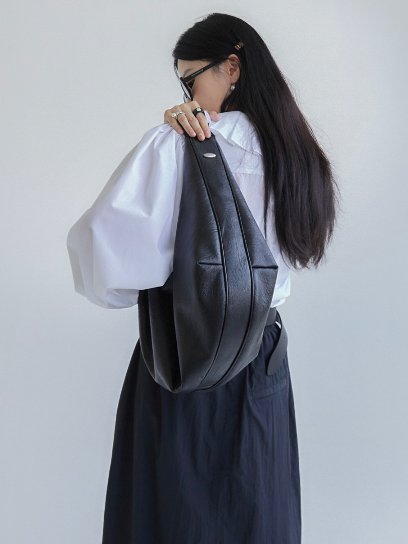 Woman wearing a black leather backpack on her shoulder