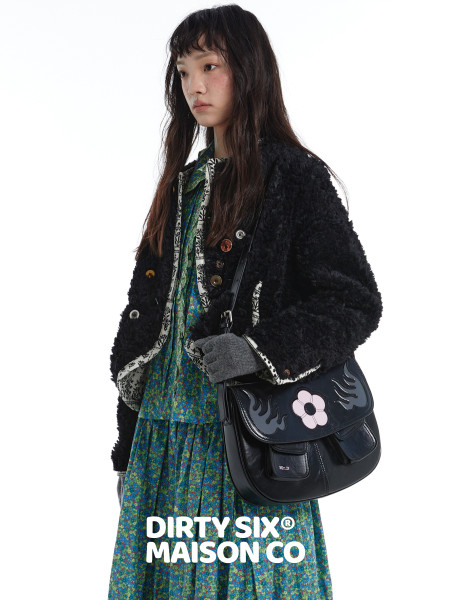 Model wearing a black fuzzy jacket with a floral dress and black shoulder bag