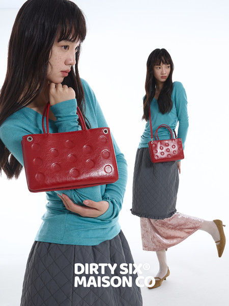 Red textured handbag shown on a fashion model
