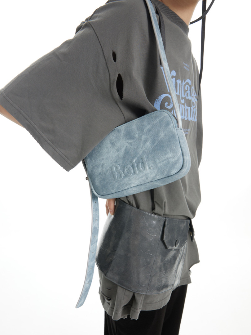 Model wearing a gray oversized graphic T-shirt with two crossbody bags