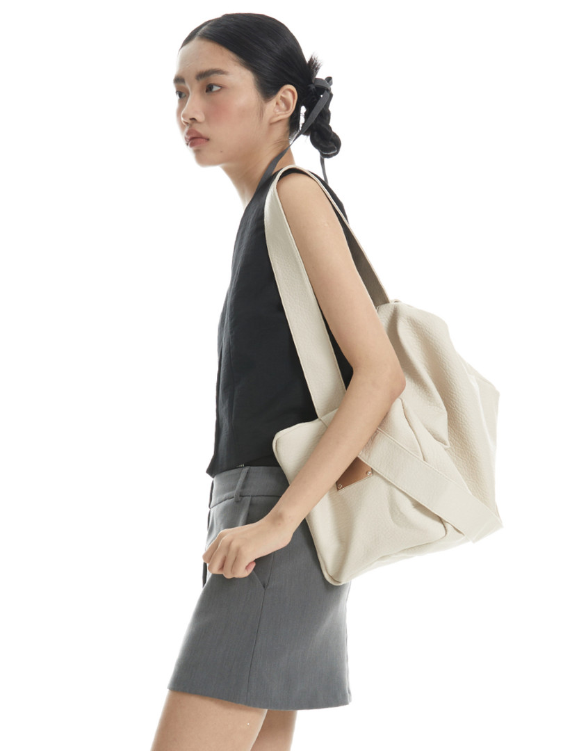 Cream oversized tote bag worn on a model