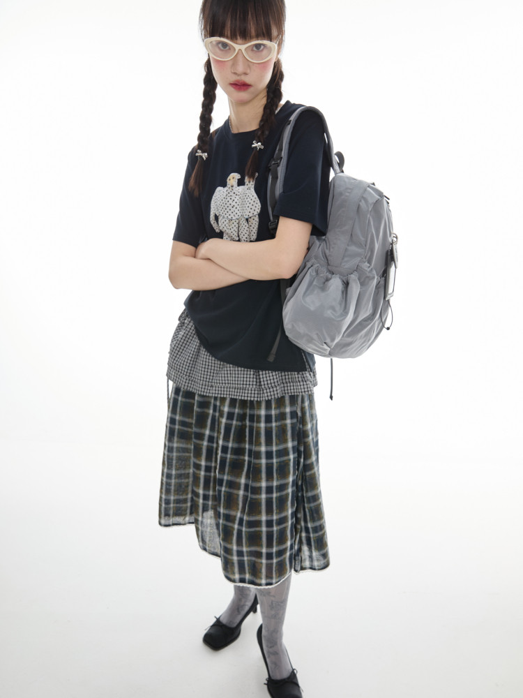 Fashion model wearing a casual layered outfit with a gray backpack