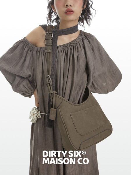 Model wearing a taupe off-shoulder dress with a crossbody bag