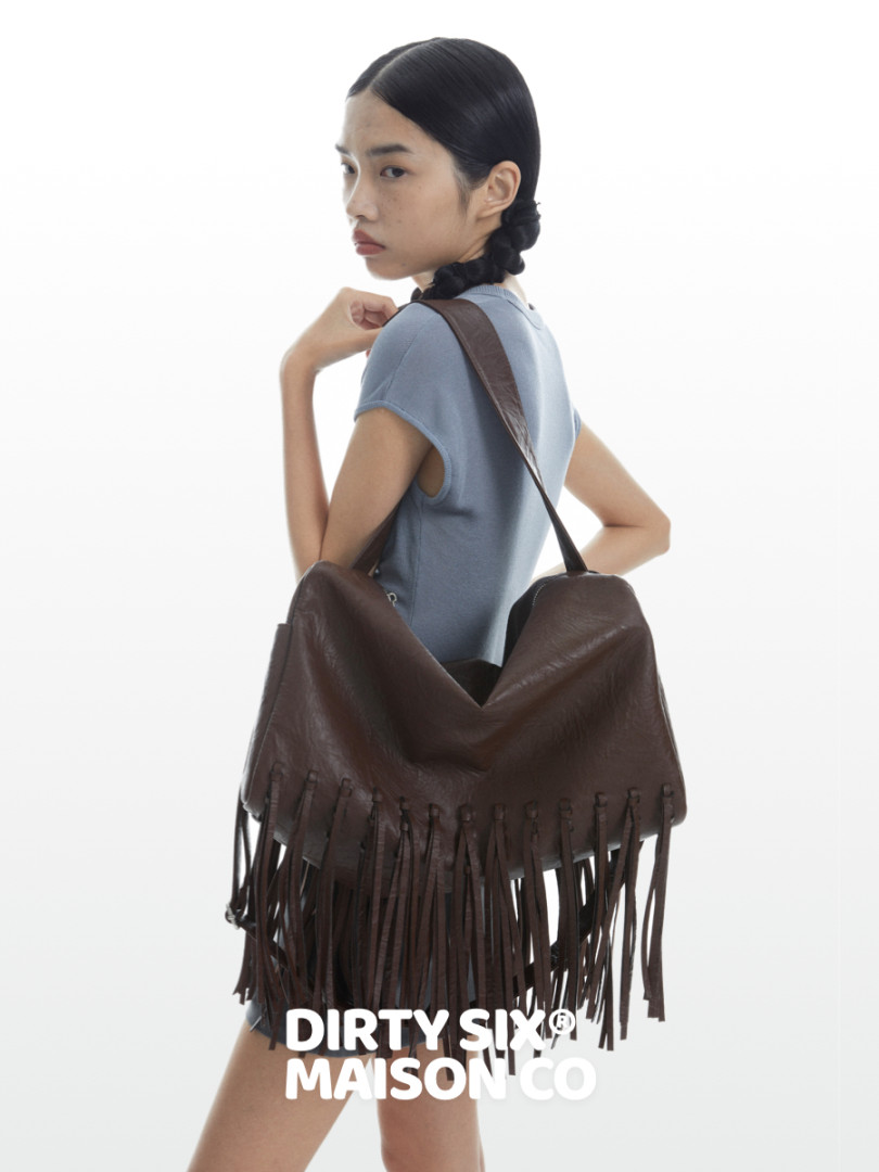 Model wearing a brown fringe shoulder bag