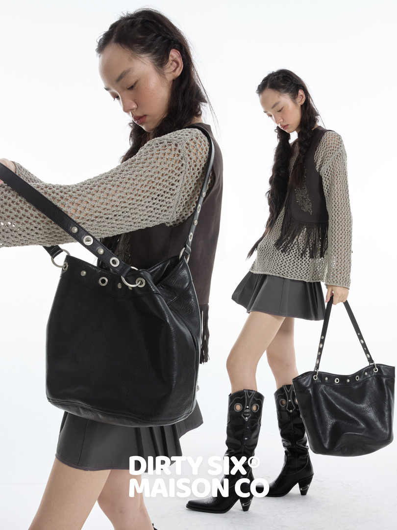 Black leather shoulder tote bag worn by a model in a fashion editorial image