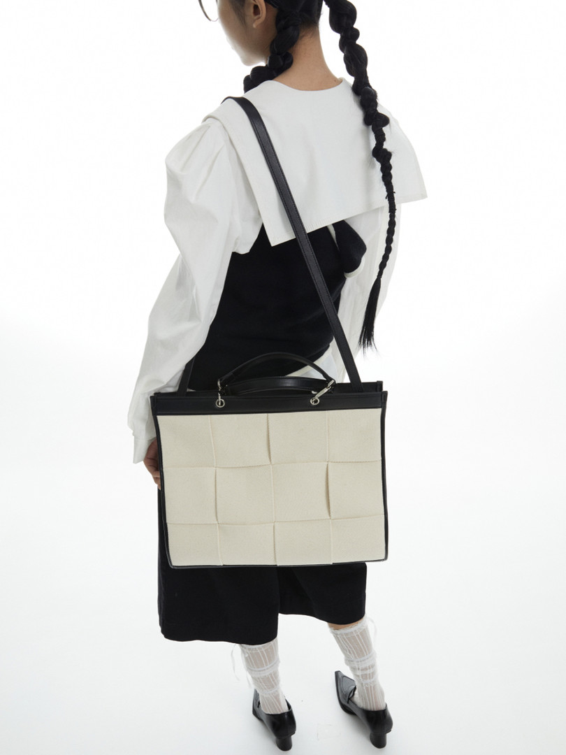 Woman wearing a black and cream shoulder tote bag