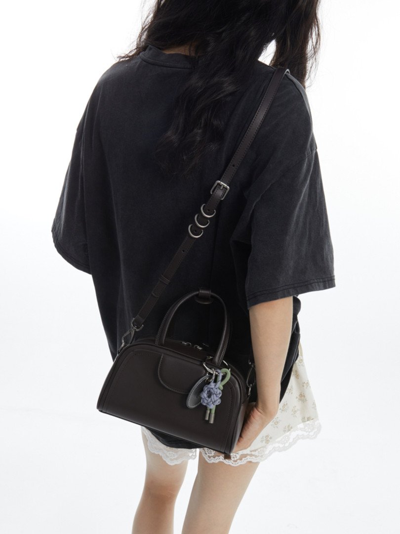 Black mini handbag worn crossbody on a model