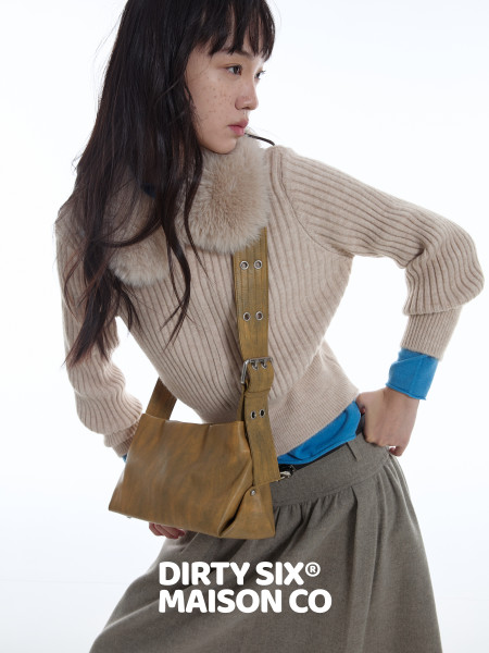 Model wearing a beige ribbed sweater with a brown crossbody bag