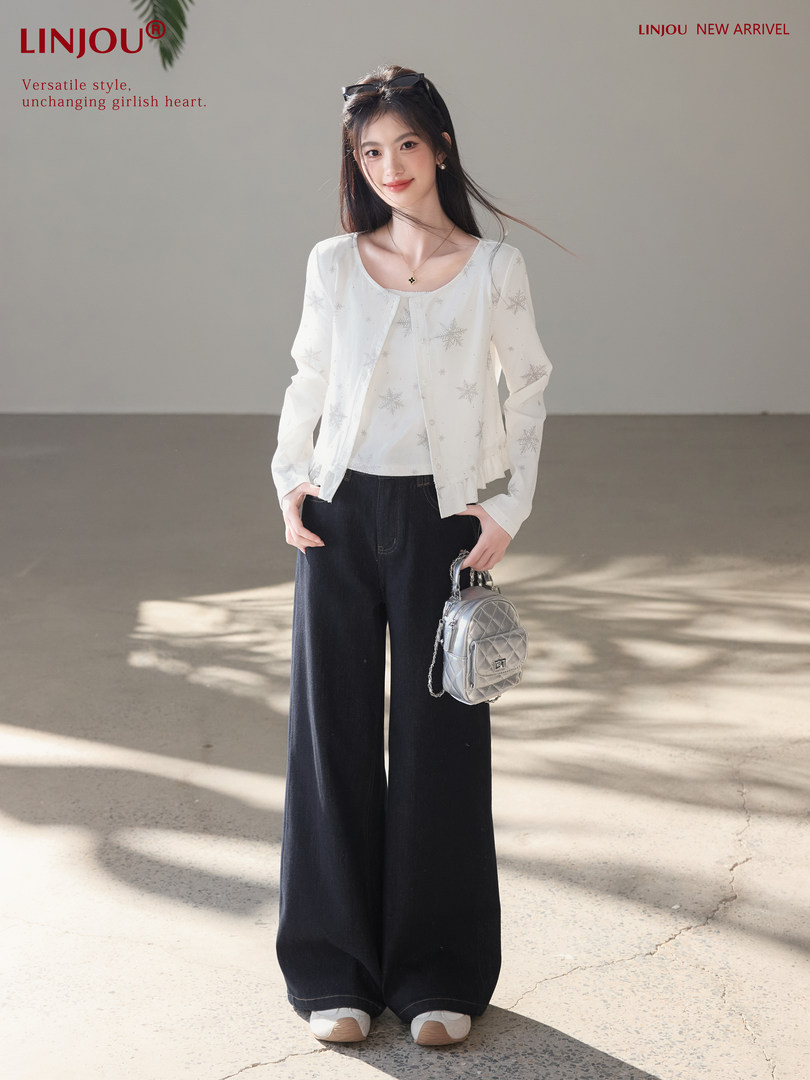 Woman modeling a white star-pattern cardigan with black wide-leg pants and a silver mini backpack