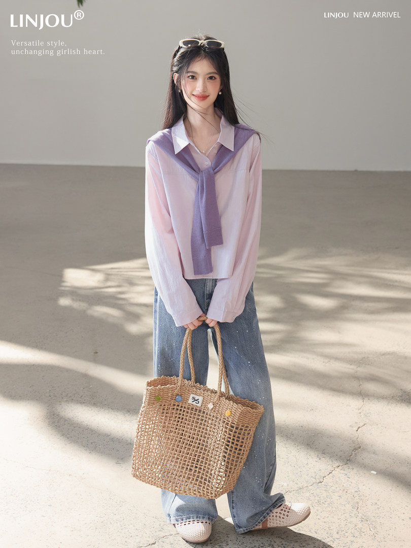 Model wearing a pastel shirt and jeans while holding a woven straw tote bag