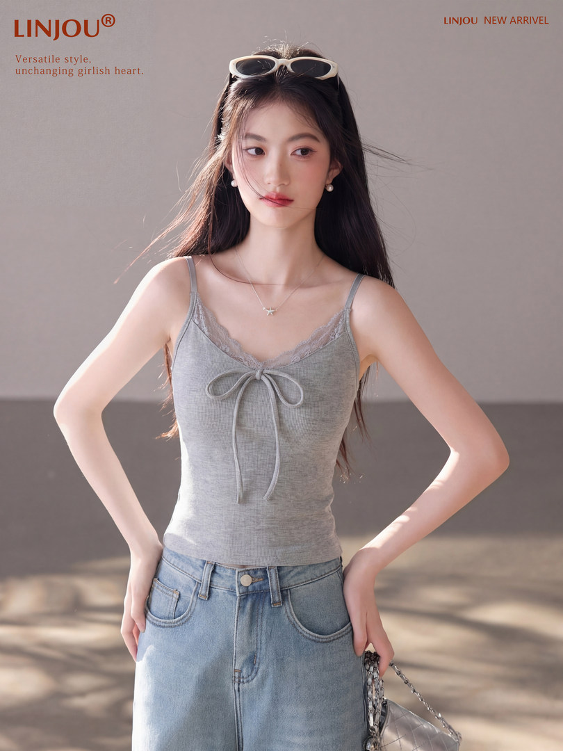 Model wearing a gray lace-trim camisole top with light blue jeans