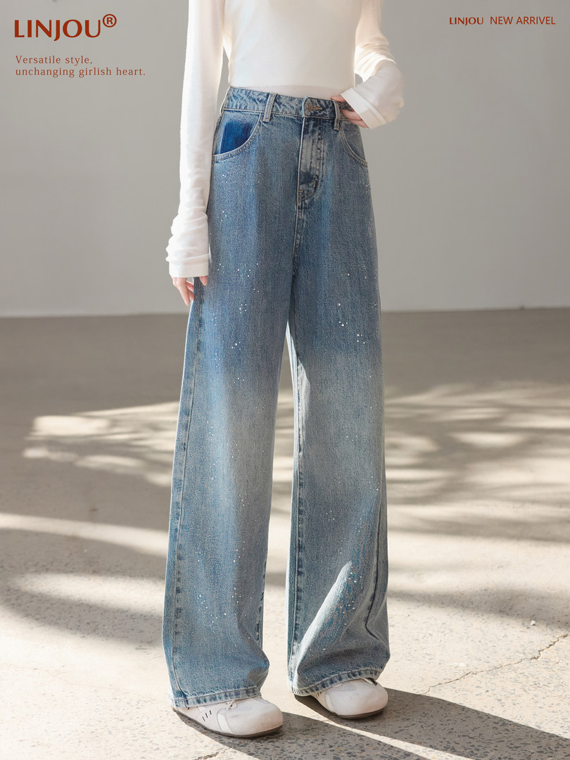 Model wearing light blue wide-leg denim jeans with subtle sparkly details
