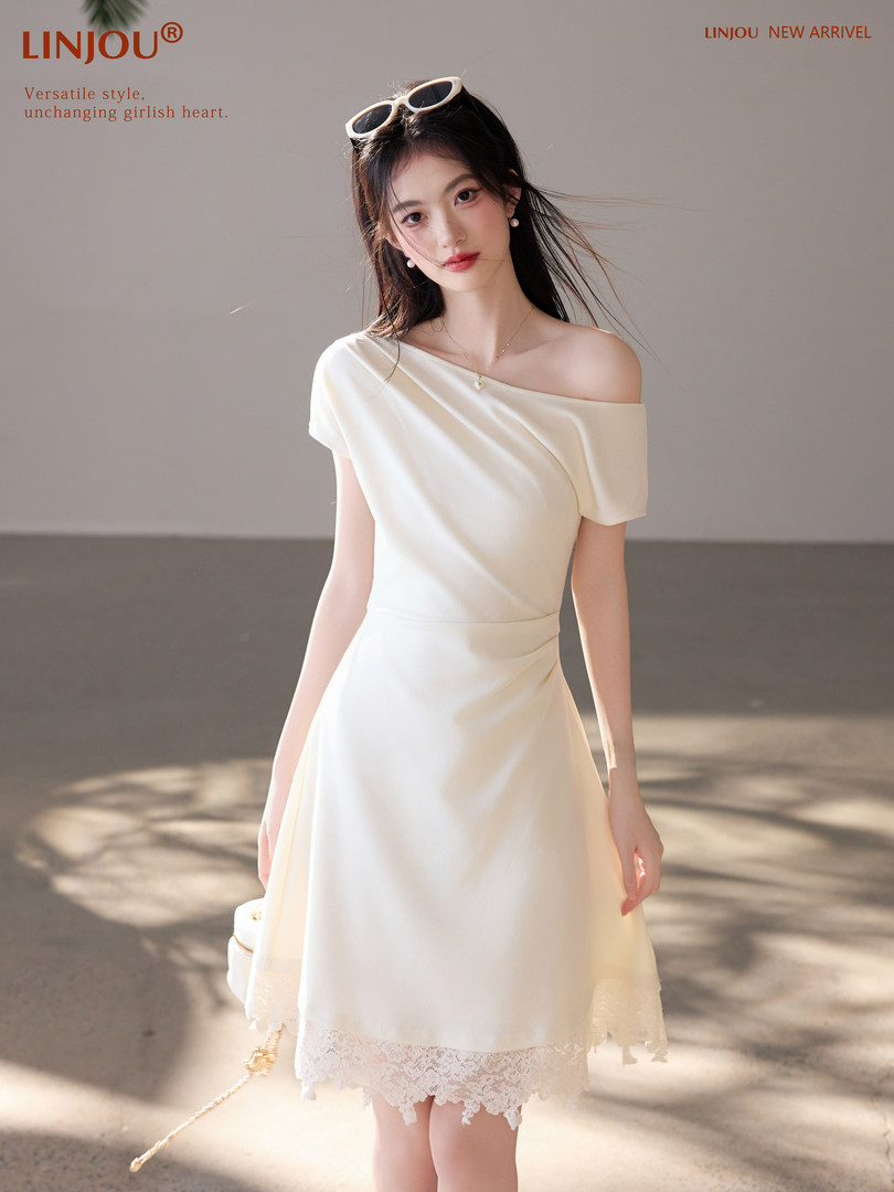 Model wearing a cream off-shoulder dress with lace trim