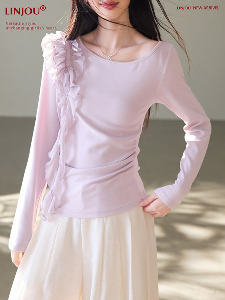 Model wearing a light pink long-sleeve ruffled top