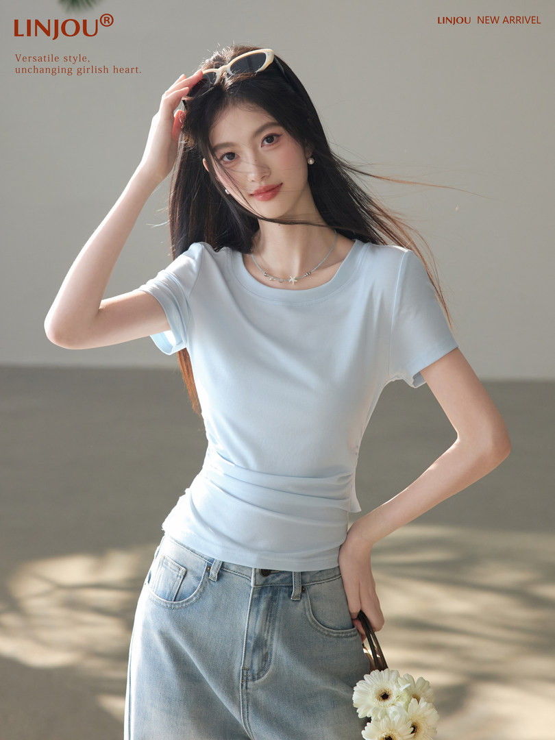 Model wearing a light blue fitted short-sleeve T-shirt with jeans