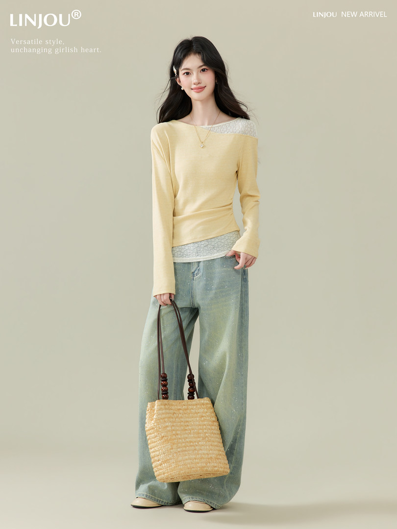 Fashion model wearing a pale yellow long-sleeve top with wide-leg jeans and a straw tote bag