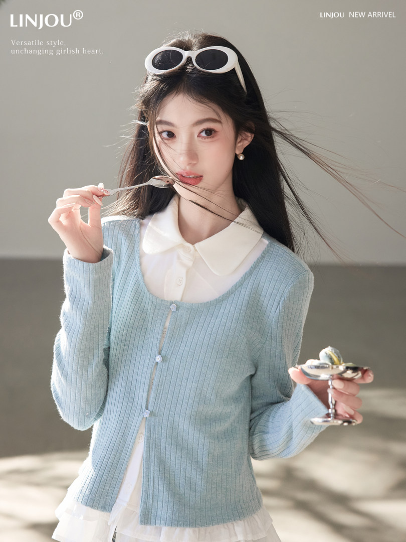 Model wearing a light blue ribbed cardigan over a white blouse