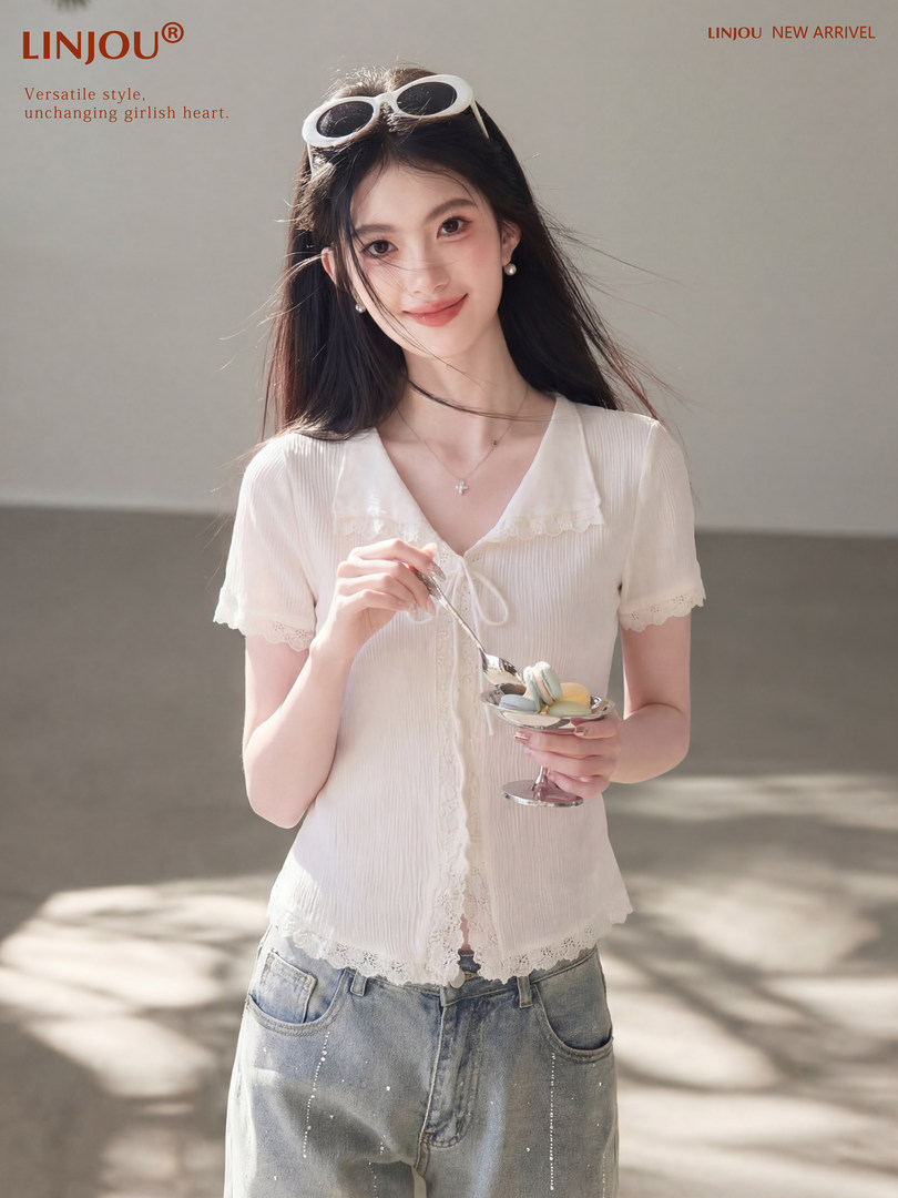 Woman wearing a white lace-trim short-sleeve blouse and light blue jeans